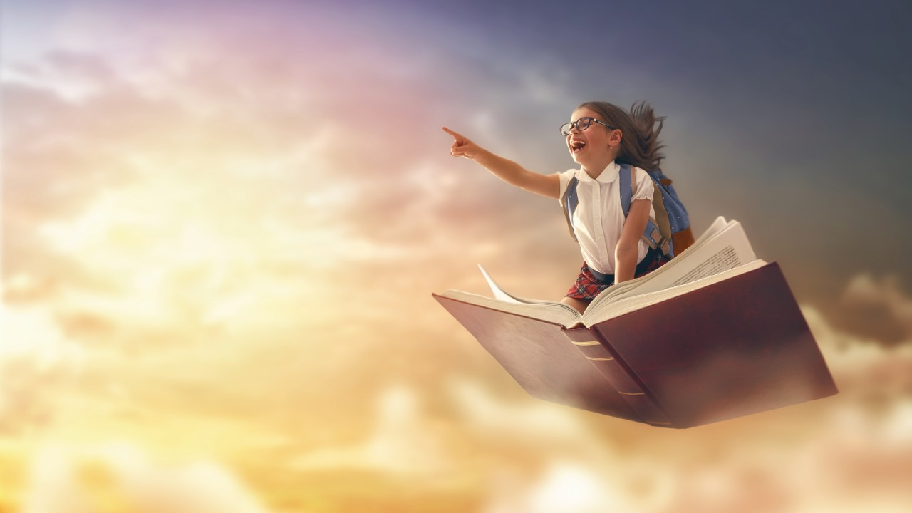 Enfant assis sur un livre géant volant dans un ciel lumineux, pointant l’horizon