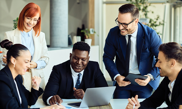 Équipe professionnelle réunie autour d’un ordinateur portable, échange et collaboration